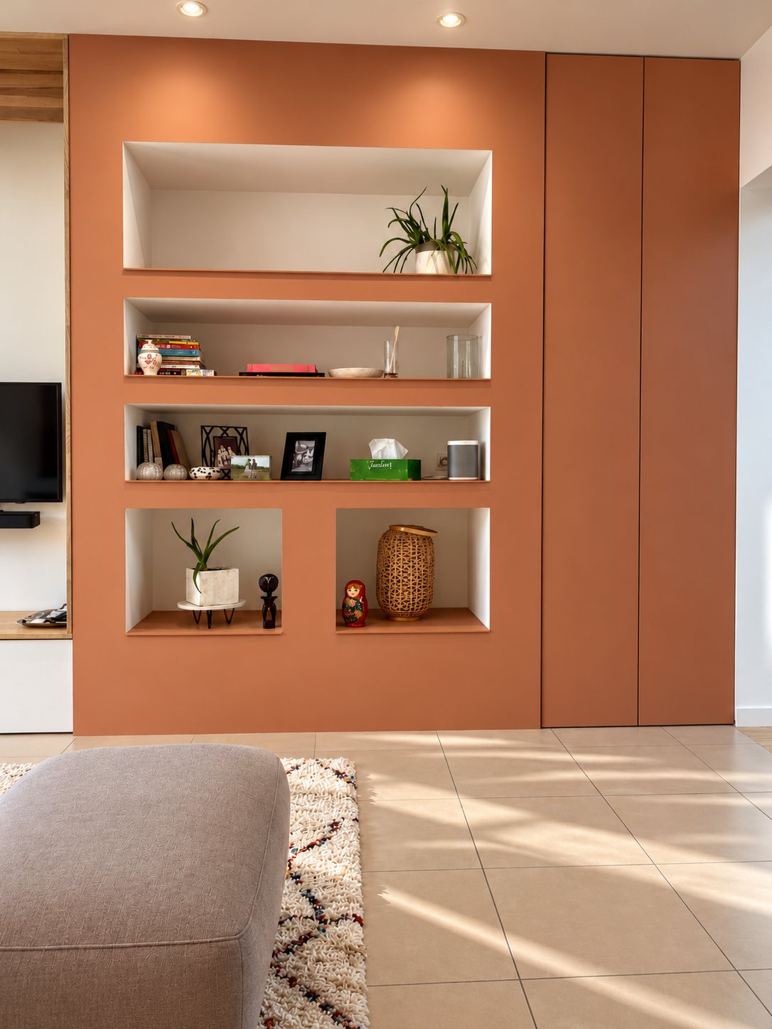 Salon lumineux avec coin banquette sous la fenêtre, encadrement en chêne et meuble TV sur mesure