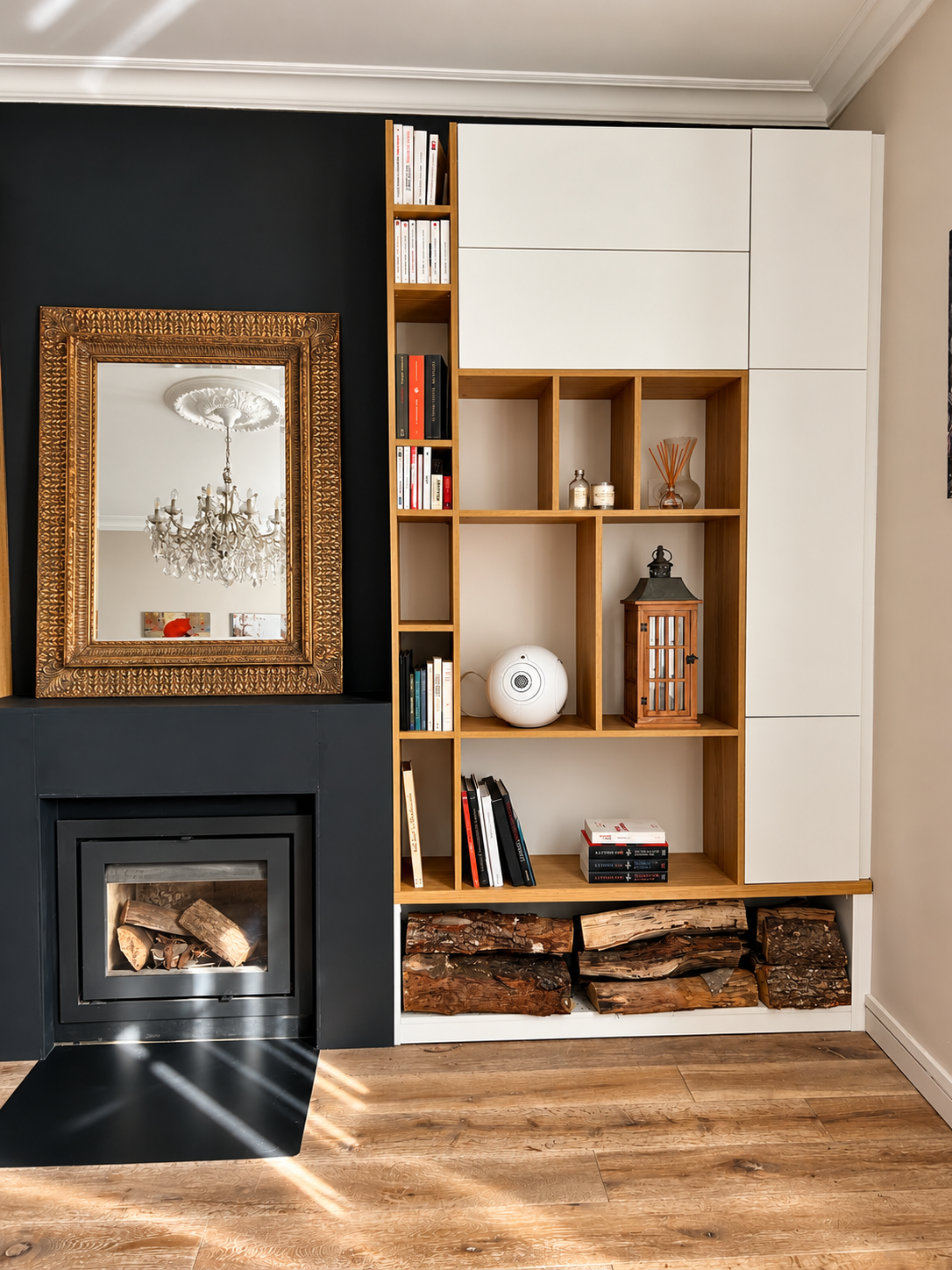 Salon élégant avec bibliothèque sur mesure, cheminée noire, parquet en bois