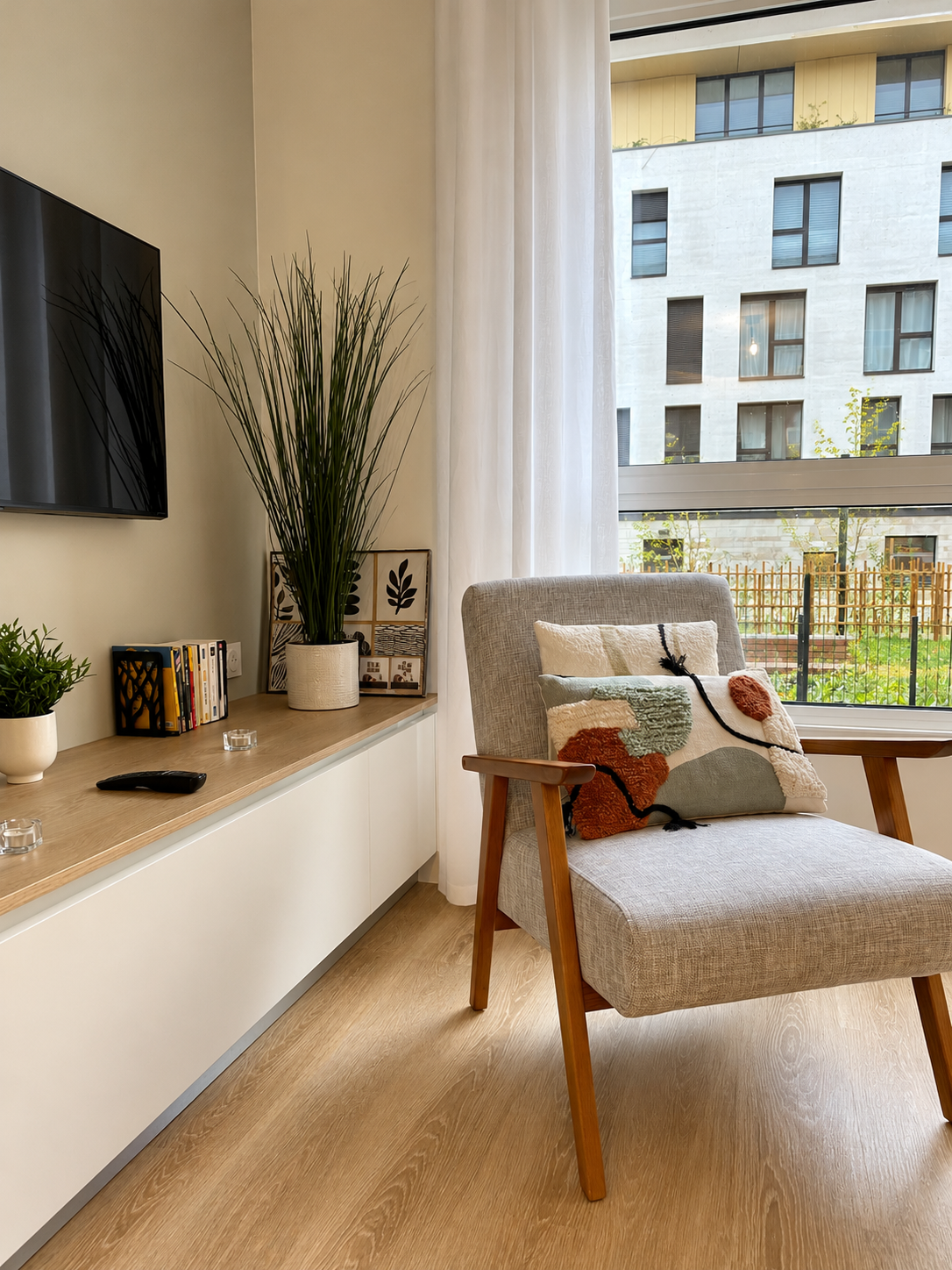 Pièce de vie lumineuse et contemporaine réunissant salon cosy, salle à manger et cuisine ouverte, avec mobilier en bois clair, touches de couleurs, matières naturelles et décoration soignée dans une ambiance chaleureuse et harmonieuse.