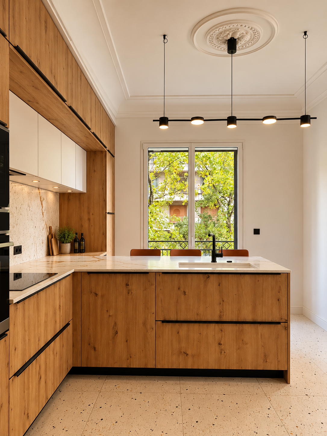 Vue d’une cuisine contemporaine sur mesure, associant des façades en chêne naturel et des meubles hauts blancs aux lignes épurées. La crédence et le plan de travail en marbre clair veiné apportent une touche élégante, tandis que trois tabourets hauts terracotta aux assises blanches habillent l’espace repas. Les éclairages intégrés et les finitions noires soulignent le design moderne et chaleureux de l’ensemble.